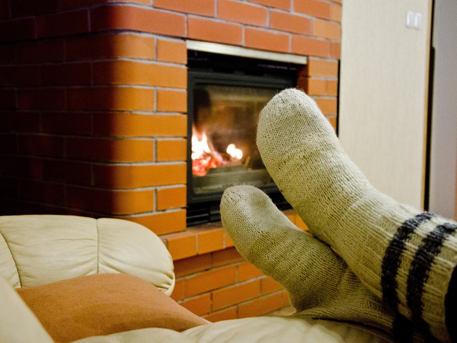 Someone sitting in the front of fireplace.