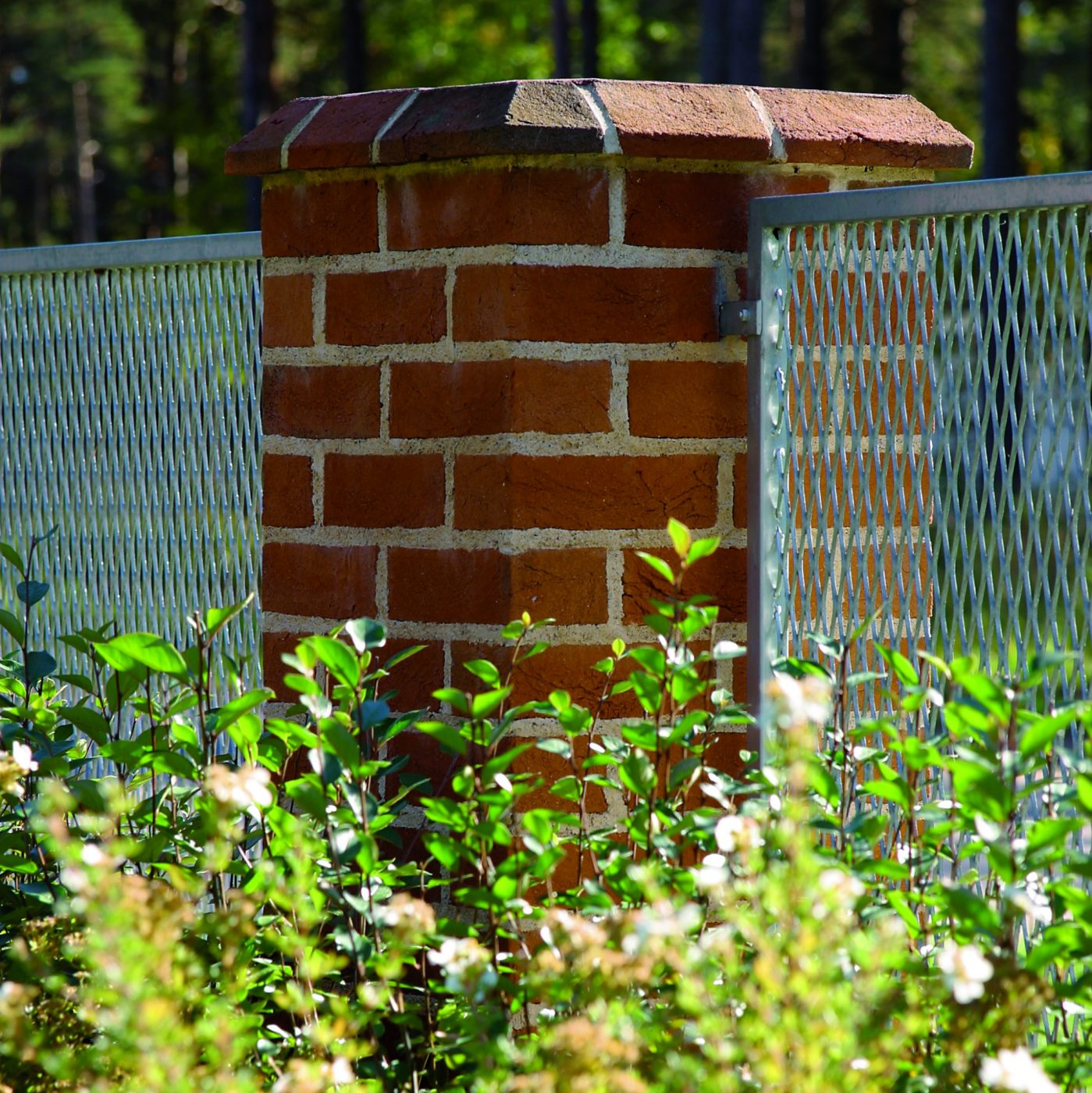    Brick pillar of St. John's bricks with some plants around
